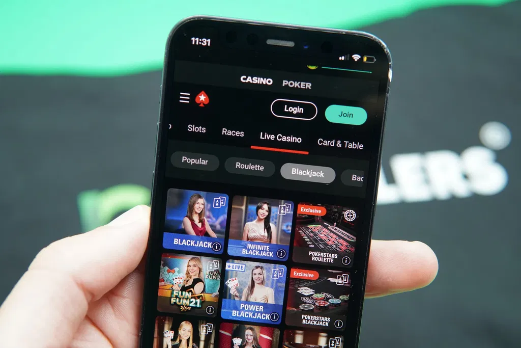 Hand holding an iPhone showing a mobile casino or slot game interface